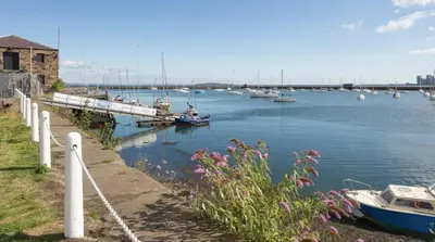 a marina with boats in the water and flowers at Comfortable Double Room, Great Transport to City Centre and Airport, 5 mins to Beach, Great Value in Edinburgh