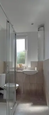 a bathroom with a glass shower and a sink at Comfortable Double Room, Great Transport to City Centre and Airport, 5 mins to Beach, Great Value in Edinburgh