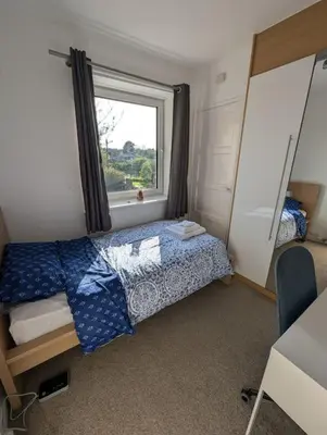 a small bedroom with a bed and a window at Lovely 3-Bed Edinburgh Flat in Edinburgh