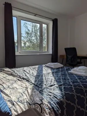a bedroom with a large bed and a window at Lovely 3-Bed Edinburgh Flat in Edinburgh
