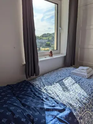 a bedroom with a bed and a window with a view at Lovely 3-Bed Edinburgh Flat in Edinburgh
