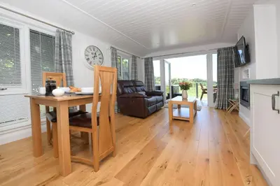 a kitchen and living room with a table and chairs at Argyll View in Langbank