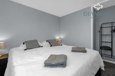 a bedroom with a white bed with two pillows at Brand New 4 Bedroom House - Sleeps 4 Fully Equipped, Free Parking, WiFi, Perfect for CONTRACTORS by Diamond Short Lets in Rosyth