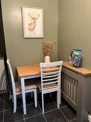 a dining room table with a white table and chairs at Kirkton Rest in Cardross