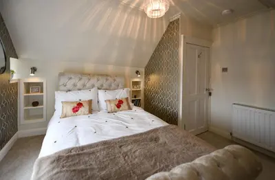 a bedroom with a large white bed with flowers on it at Ayrbados - 4 bed townhouse in Ayr in Ayr