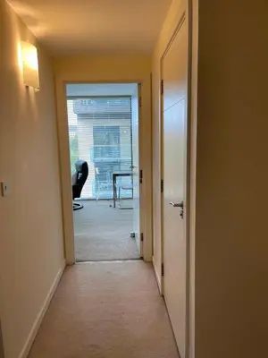 an empty hallway with a door leading to a dining room at Glasgow Harbour River West End in Glasgow