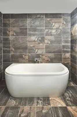a white bath tub in a tiled bathroom at Craig Chat in Oban