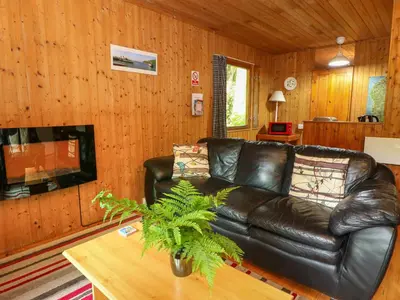 a living room with a leather couch and a tv at Lodge 3 - 