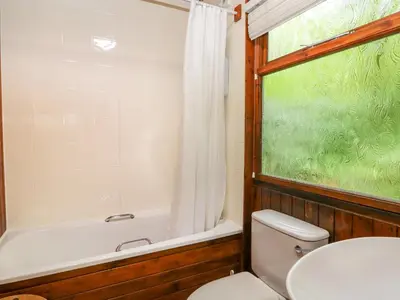 a bathroom with a toilet and a tub and a window at Lodge 3 - 
