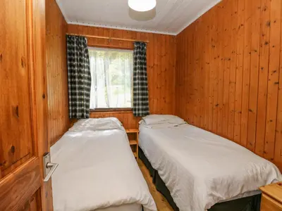 two beds in a room with wooden walls at Lodge 6 - 