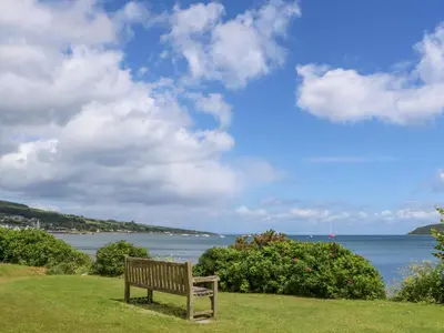 a bench sitting on the grass near the water at Lodge 6 - 
