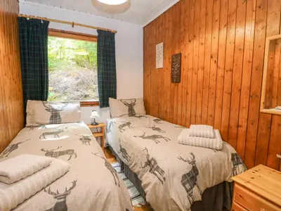 two beds in a room with wooden walls at Lodge 4 - 
