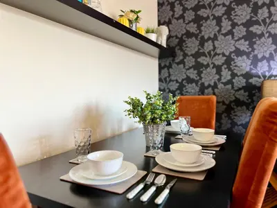 a black table with plates and utensils on it at Stylish Modern Flat with Juliet Balcony & Parking in Glasgow