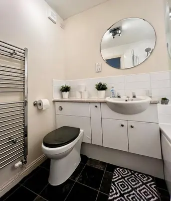 a bathroom with a toilet and a sink and a mirror at Stylish Modern Flat with Juliet Balcony & Parking in Glasgow