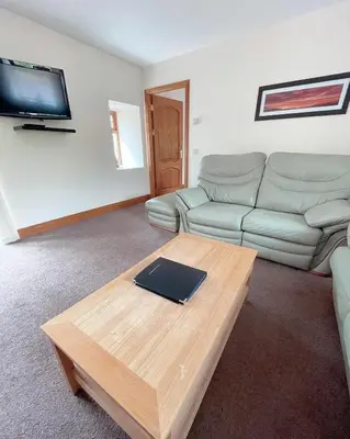 a living room with a couch and a coffee table at Dungavel Cottage in Roberton