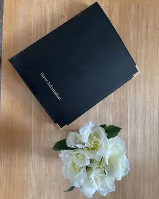 a black book and a bouquet of white flowers at Dungavel Cottage in Roberton