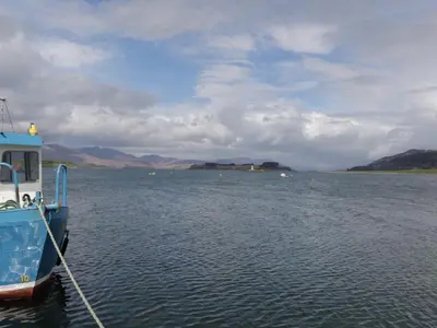 a blue boat is docked on a body of water at Tirlaggan House in Oban