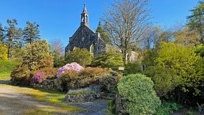 a church with a clock tower in a garden at The Garden Flat in Fort William