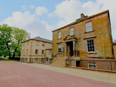 an old brick building with stairs in front of it at Knightsridge House in Livingston