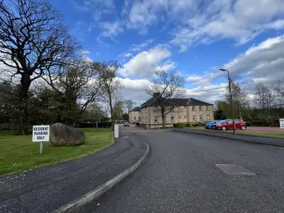 a sign on the side of a road next to a house at Knightsridge House in Livingston