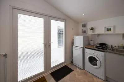 a kitchen with a washer and dryer next to a window at Hunter Links Cottage in Prestwick