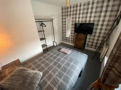 a bedroom with a bed and a tv in it at Shore Cottage in Girvan