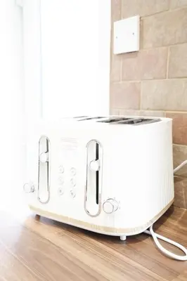 a white toaster sitting on top of a wooden floor at Rhyber Avenue in Lanark