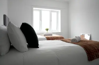 a bedroom with two beds with pillows and a window at Rhyber Avenue in Lanark