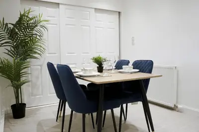 a dining room with a wooden table and blue chairs at Rhyber Avenue in Lanark