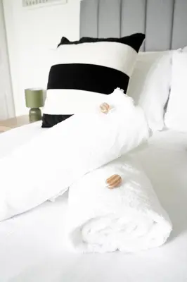 a bed with white towels and pillows on it at Rhyber Avenue in Lanark