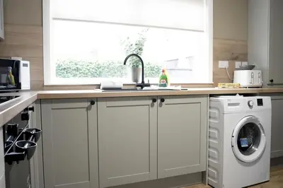 a kitchen with a washer and dryer under a window at Barclay House in Livingston