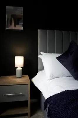 a bedroom with a bed with a lamp on a nightstand at Barclay House in Livingston