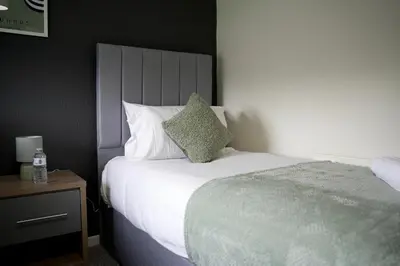 a bedroom with a bed with a green pillow on it at Calgary House in Livingston