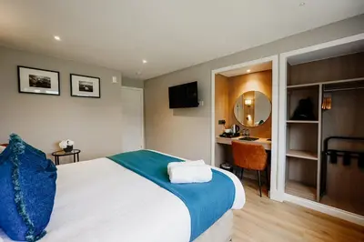 a bedroom with a bed and a desk and a mirror at Powfoulis Inn in Falkirk