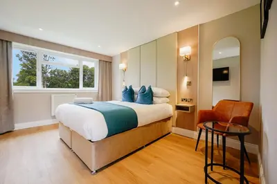 a bedroom with a large bed with blue pillows at Powfoulis Inn in Falkirk
