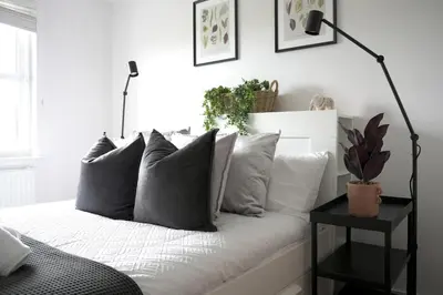 a bedroom with a bed with gray pillows at Sunnyside Penthouse in Coatbridge