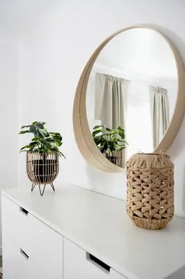 a mirror on a white dresser with two plants at Sunnyside Penthouse in Coatbridge