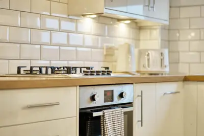 a kitchen with a stove and a counter top at Modern 2 Bed Flat with Free Parking in Glasgow