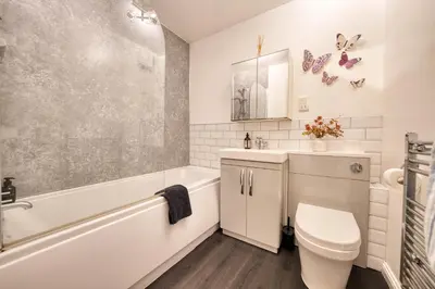 a bathroom with a toilet and a tub and a sink at Modern 2 Bed Flat with Free Parking in Glasgow