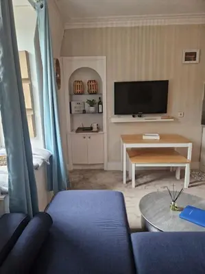 a living room with a blue couch and a table at Cumbrae Loft in Millport