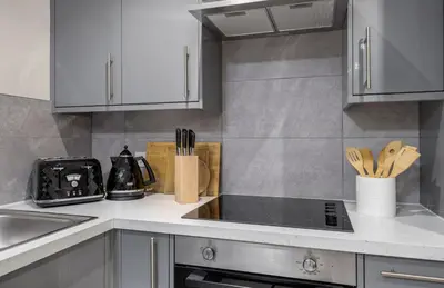 a kitchen with white cabinets and a counter top at Central Stirling City Escape in Stirling