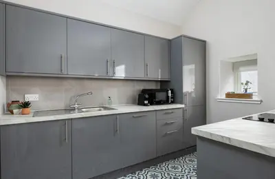 a kitchen with stainless steel cabinets and a sink at Highland Hideaway Apartment in Stirling