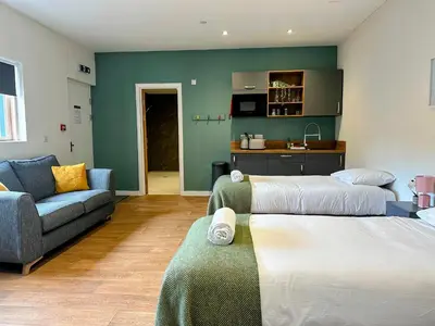 a living room with two beds and a couch at Modern Accessible Apartment with Interconnecting Room in Dolphinton