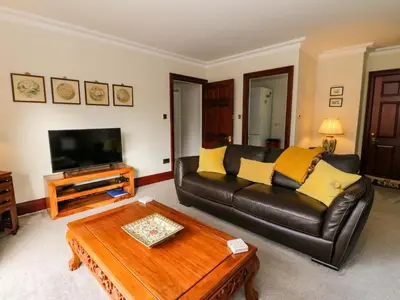 a living room with a leather couch and a coffee table at Mousebank in Lanark