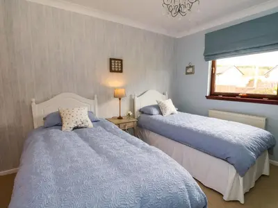 a bedroom with two beds and a window at Mousebank in Lanark