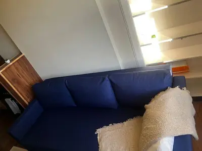 a blue couch with a pillow on top of it at One Bedroom Apartment in Gorgie with new central heating system in Edinburgh