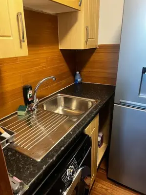 a kitchen with a sink and a refrigerator at One Bedroom Apartment in Gorgie with new central heating system in Edinburgh