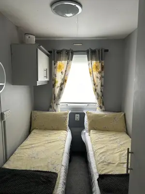 a small room with two beds and a window at Cairnryan Heights home from home in Cairnryan