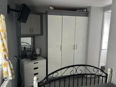 a bedroom with a bed and a dresser and a mirror at Cairnryan Heights home from home in Cairnryan