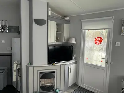 a living room with a television and a fireplace at Cairnryan Heights home from home in Cairnryan